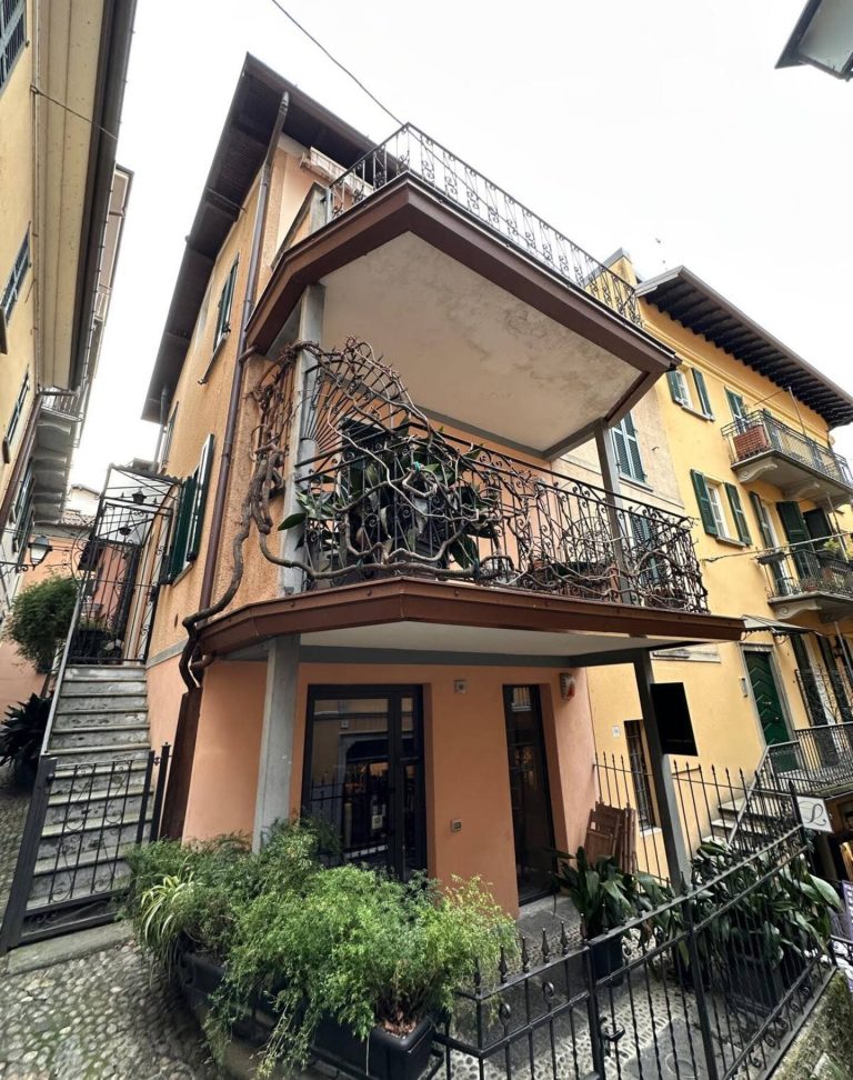 Colorful house with decorated balcony, located in a picturesque alley.