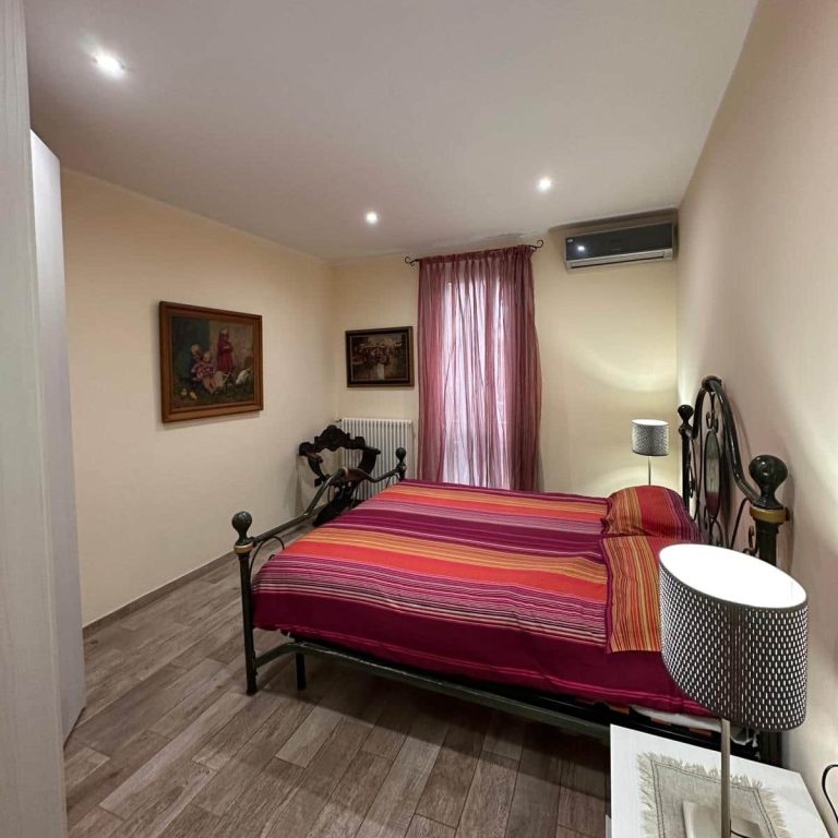 Bright room with single beds, draped curtains and artistic decorations.