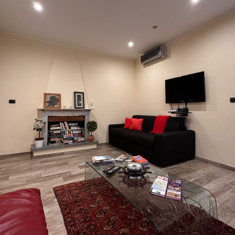 Modern living room with black sofa, red cushions, table and wall unit in Bellagio. Italian Design.